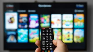 Best TV and film streaming services: Person pointing remote control at a TV screen