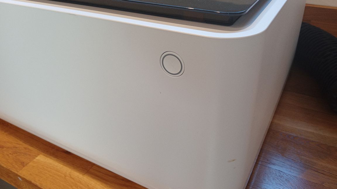 xTool M1 review; a close up of the on button of a laser cutter, it's a white box with a curved side