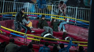 Two contestants get cornered by zombies on a merry-go-round in Zombieverse