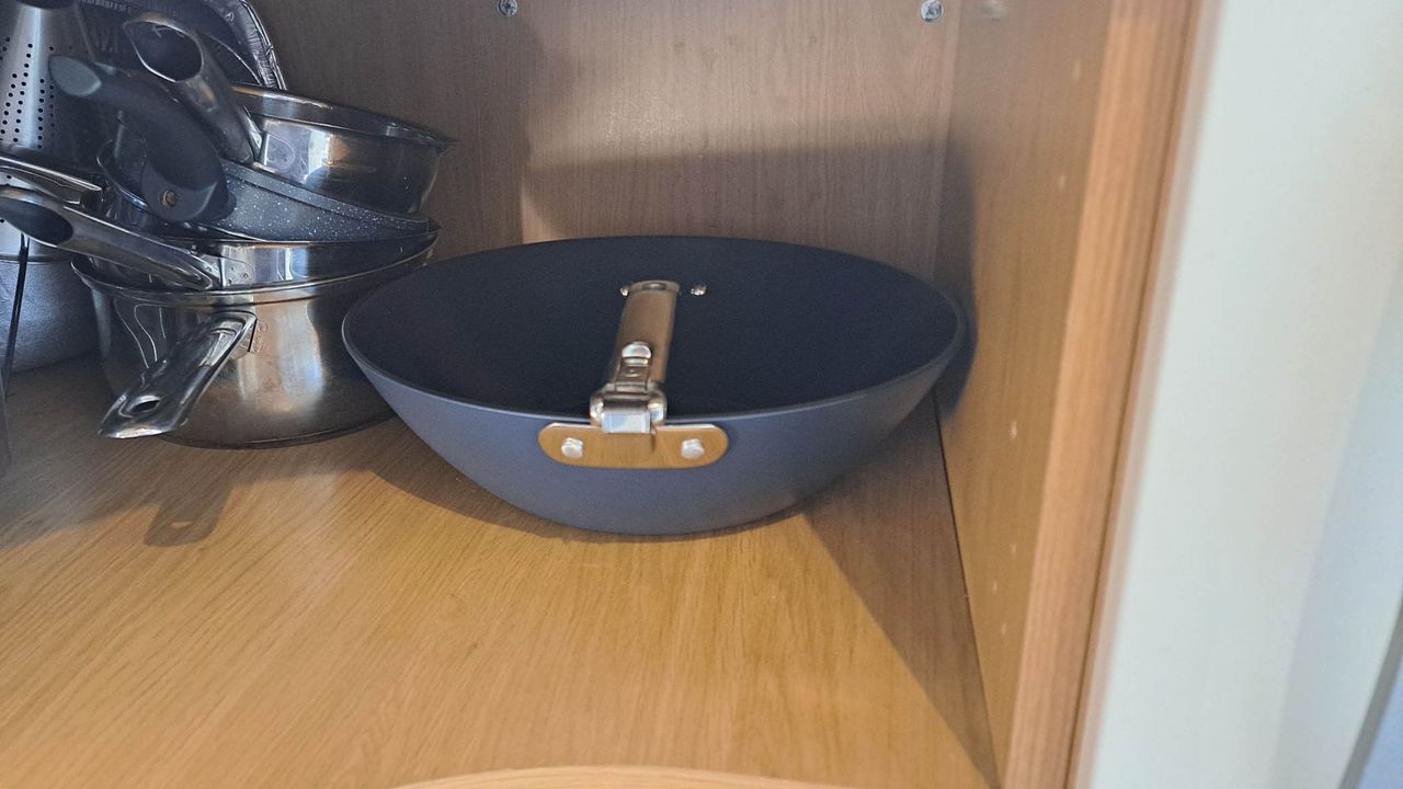 Space saving folding wok in cupboard