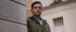 Rami Malek as Charlie Heller looking around a corner in the amateur