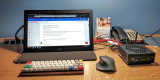 A Zotac mini PC with a portable monitor set up in a hotel room