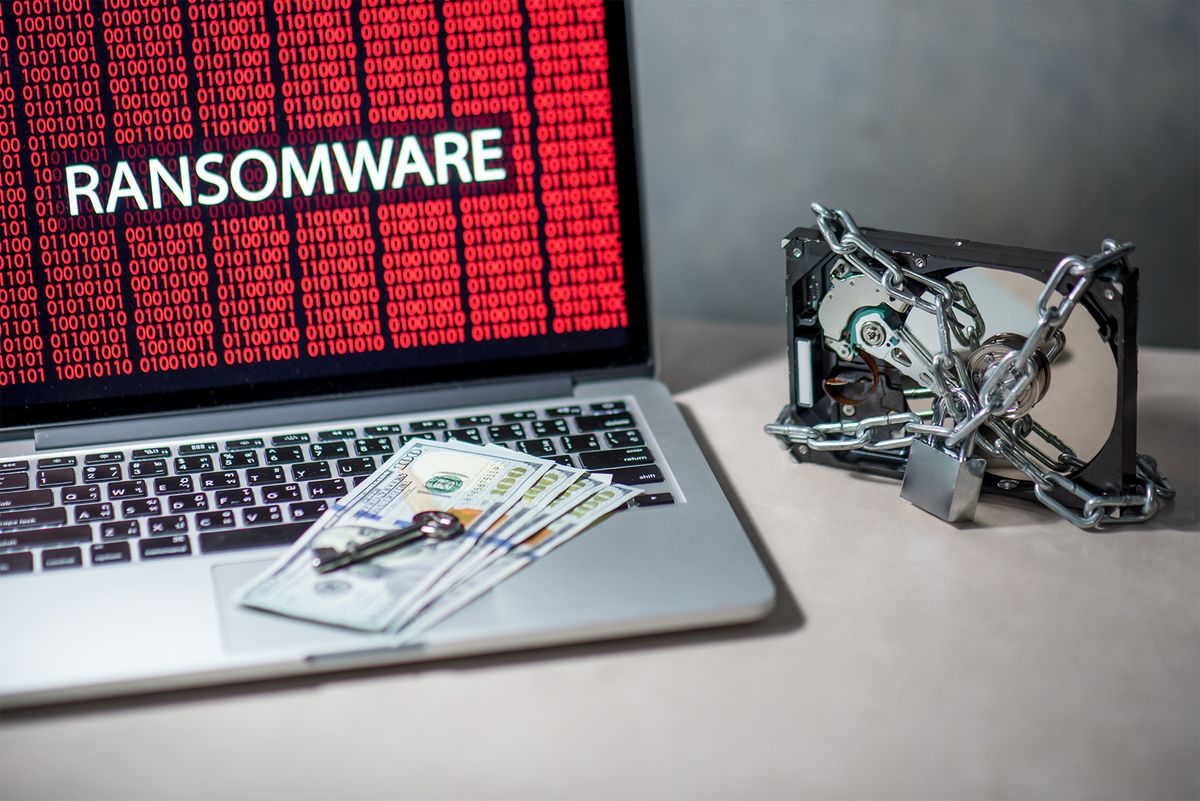 Money and keys resting on a laptop representing ransomware