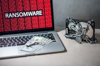 Money and keys resting on a laptop representing ransomware
