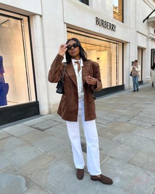 Woman in brown suede jacket and shoes.