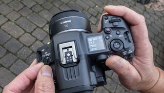 Canon EOS R5 C hybrid video camera held in a man's hands