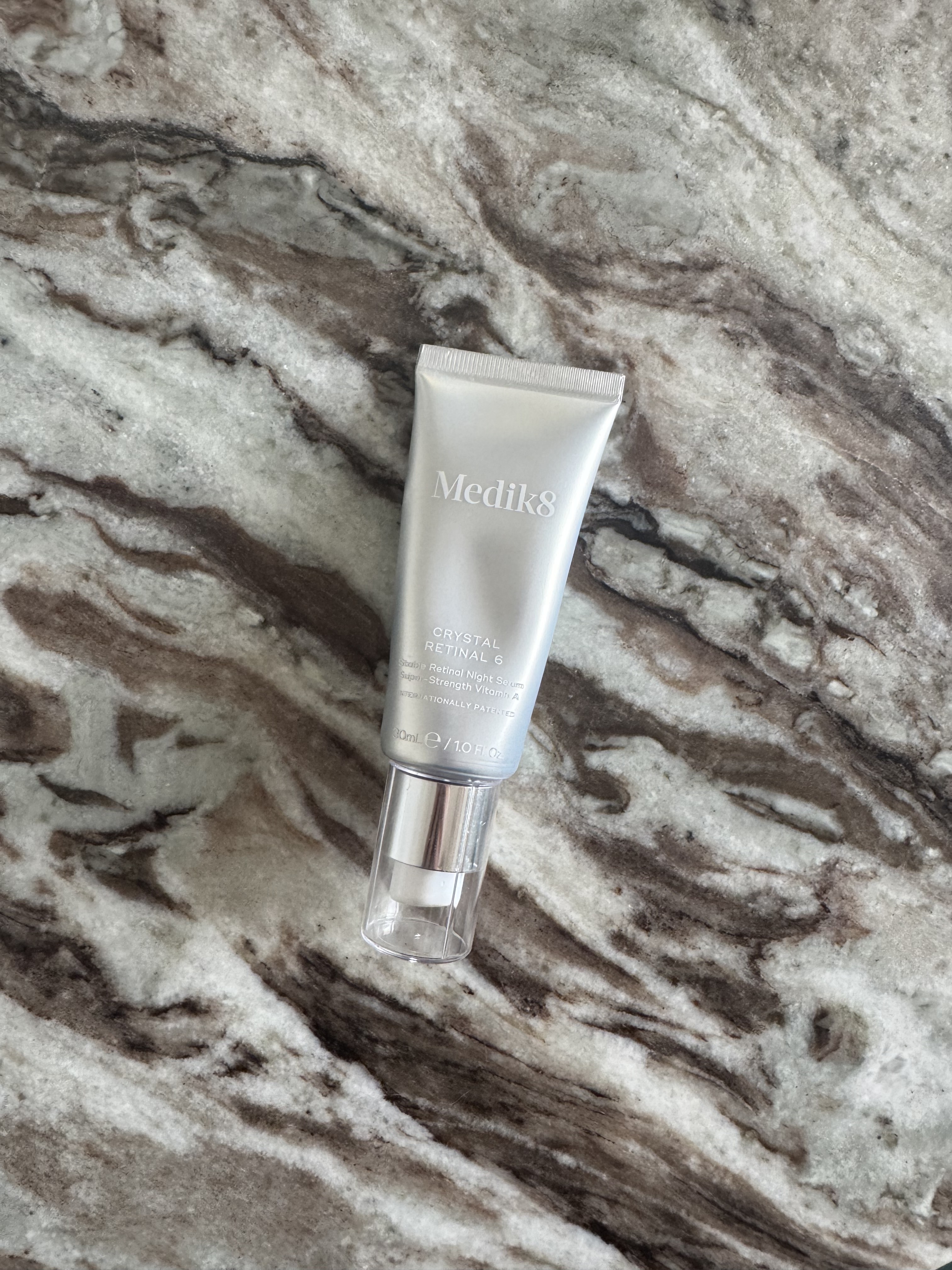 A tube of Medik8 Crystal Retinal in strength six, sitting on a marble table