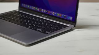 MacBook Pro 13" M2 på en bordplate i et kontormiljø.