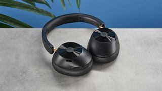 a pair of black bluetooth headphones made by OneOdio Focus A5 is photographed against a blue background