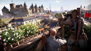 A screenshot from Sniper Elite: Resistance showing the protagonist surveying a French castle with a co-op partner