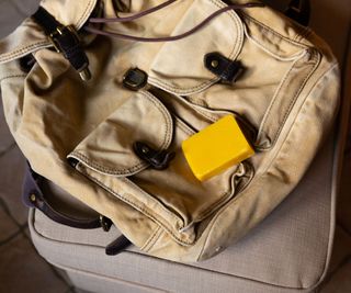 Yellow piece of wax on the backpack. Canvas backpack after laundering is prepared for waxing with natural beeswax for dirt-repellent and waterproof impregnation.