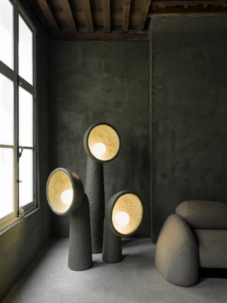 Three grey ceramic lamps with yellow lights