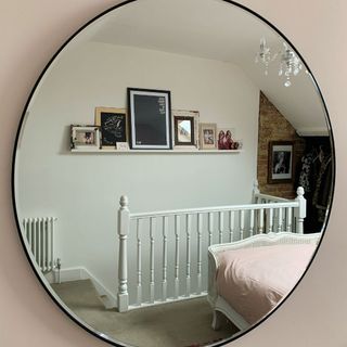 room with round mirror frame and white wall