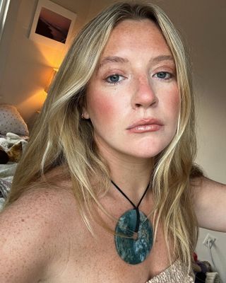 Influencer Martine Lavelle poses with a summer-ready beauty look wearing a black cord necklace with a large round turquoise medallion pendant.