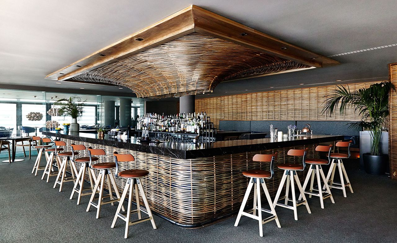 Bar area with orange stools &amp; wicker lining