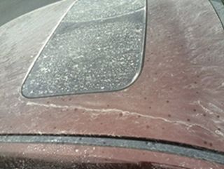 milky rain residue on red car