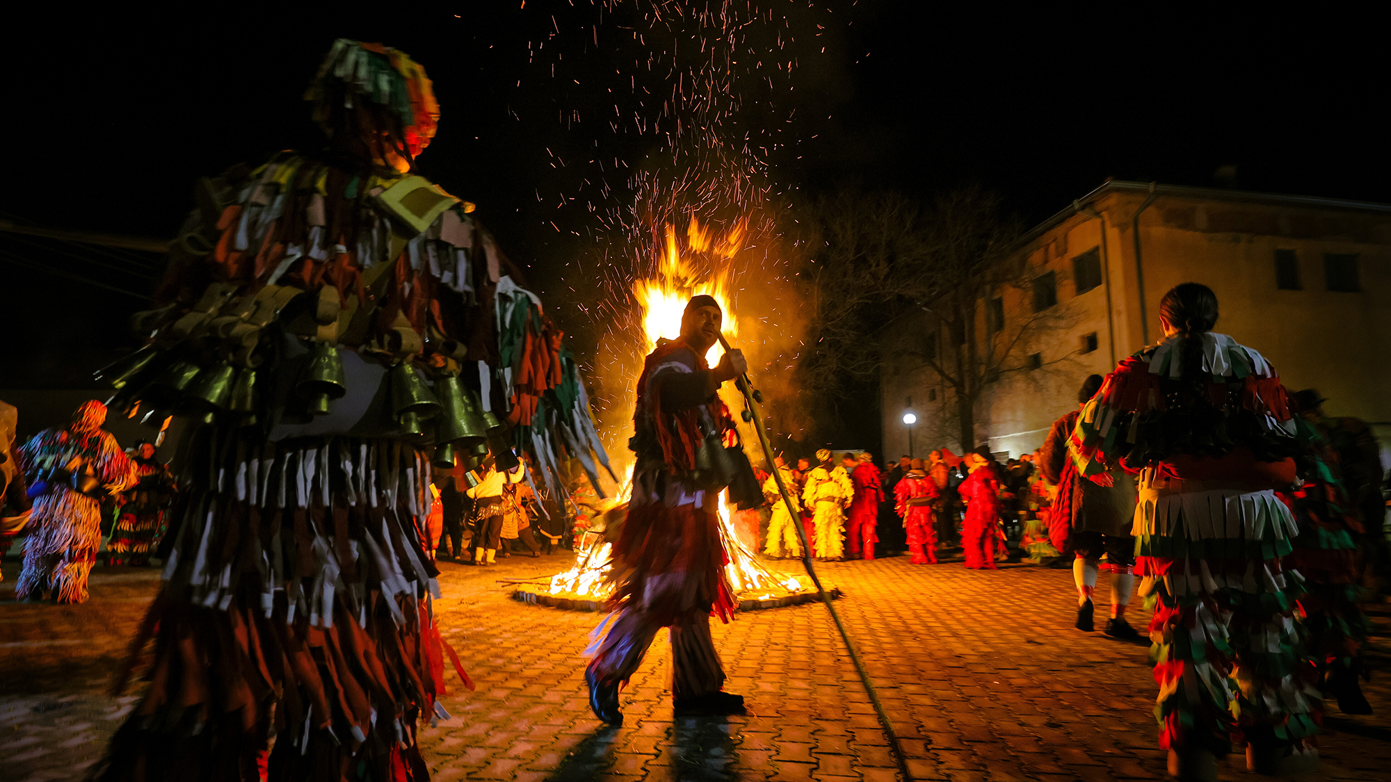 People in traditional costumes perform around a bonfire as part of the Surva festival in Svetlya, Bulgaria