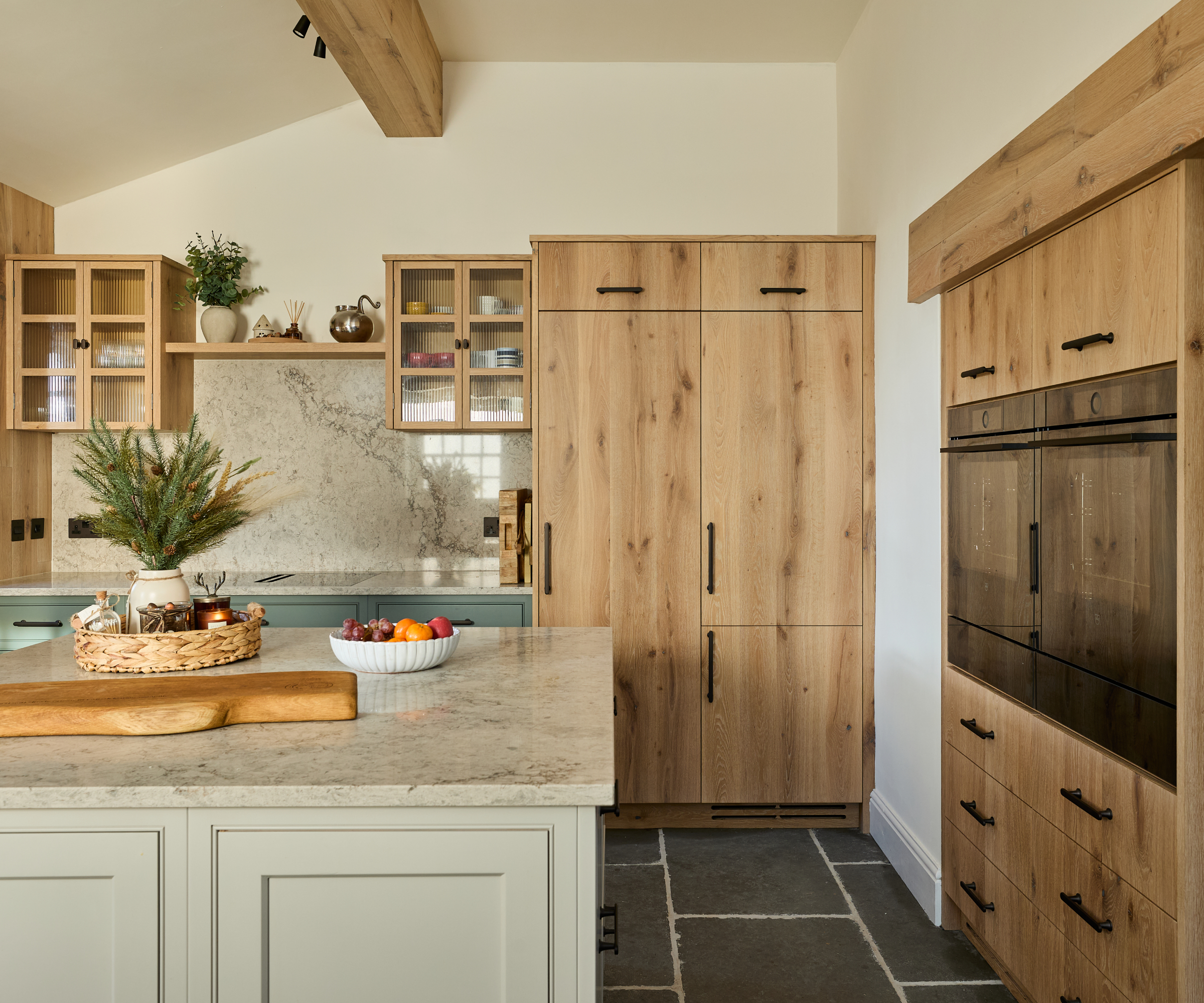 kitchen with wooden doors, kitchen island with marble worktop and green cabinets below