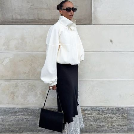 woman in a white jacket and black satin skirt