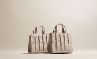 Two square cream leather handbags with vertical stripes with patterns between them on the fronts.