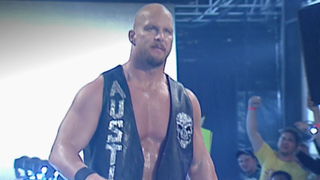 Steve Austin walks to the ring with an unbuttoned leather jacket on.