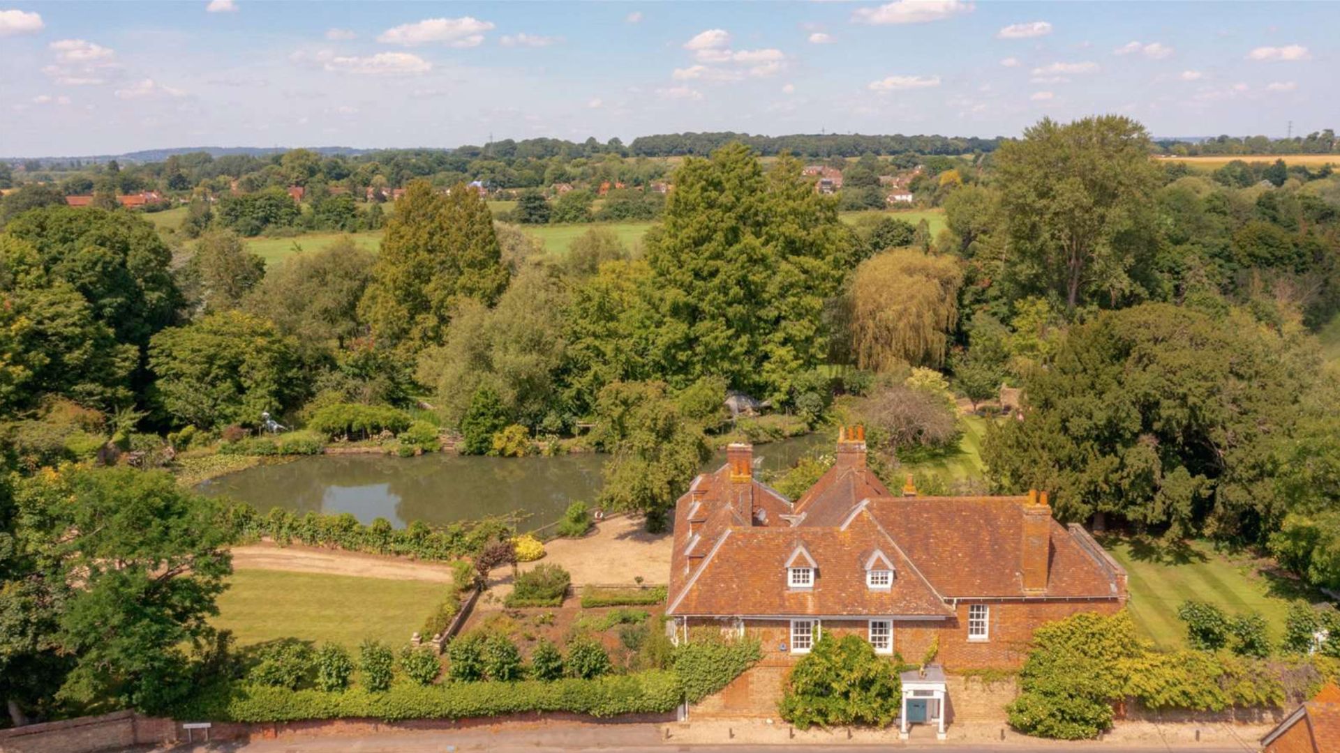 an ariel view of the property which shows the house, lakes and gardens