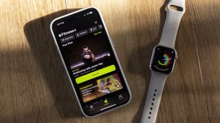 An iPhone and Apple Watch 8 with Fitness Plus on both displays