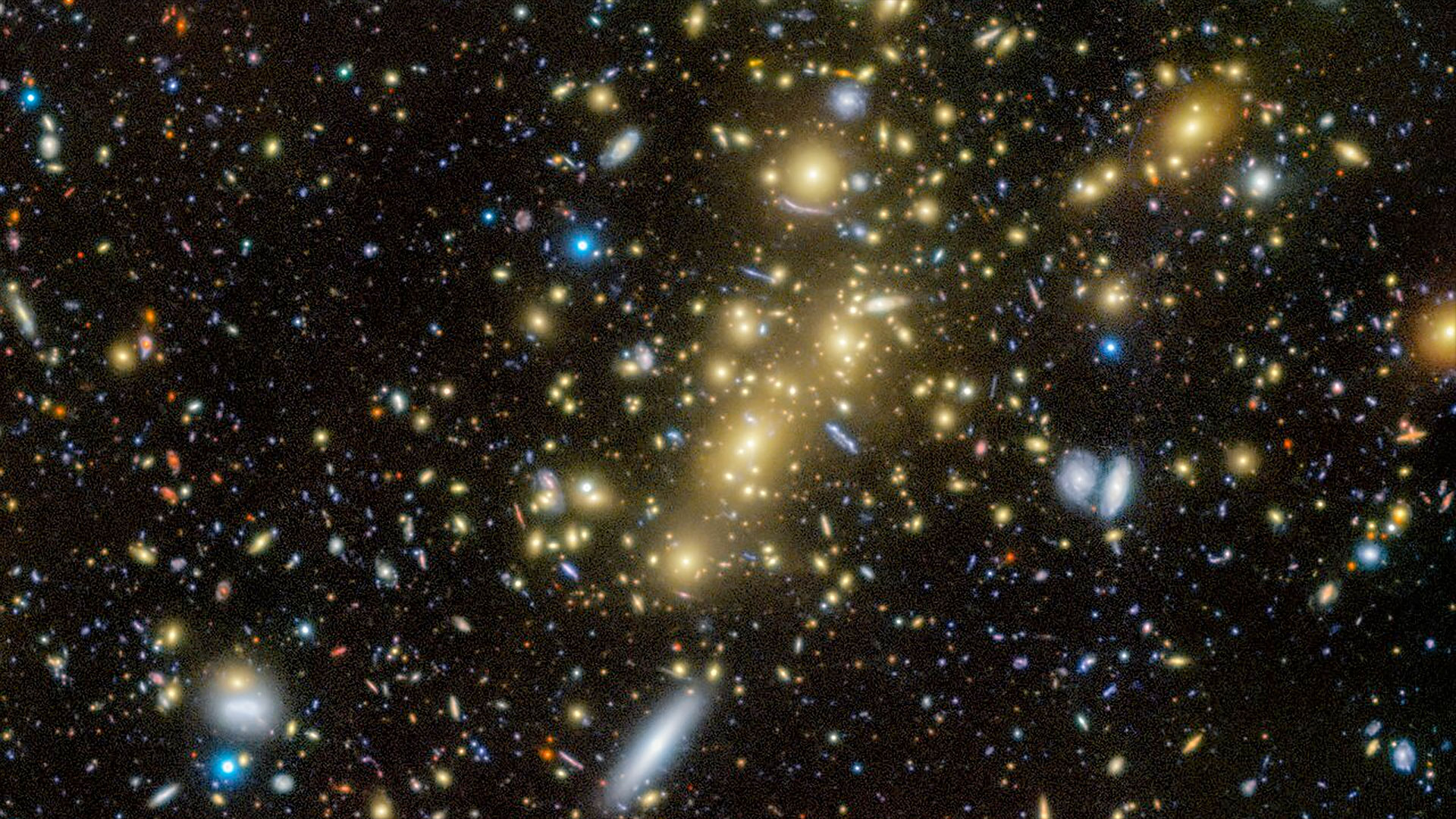a colorful cluster of globs of light, each a different galaxy, as seen through a powerful telescope