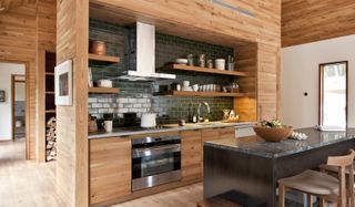 wooden kitchen cabinets with green tile backsplash