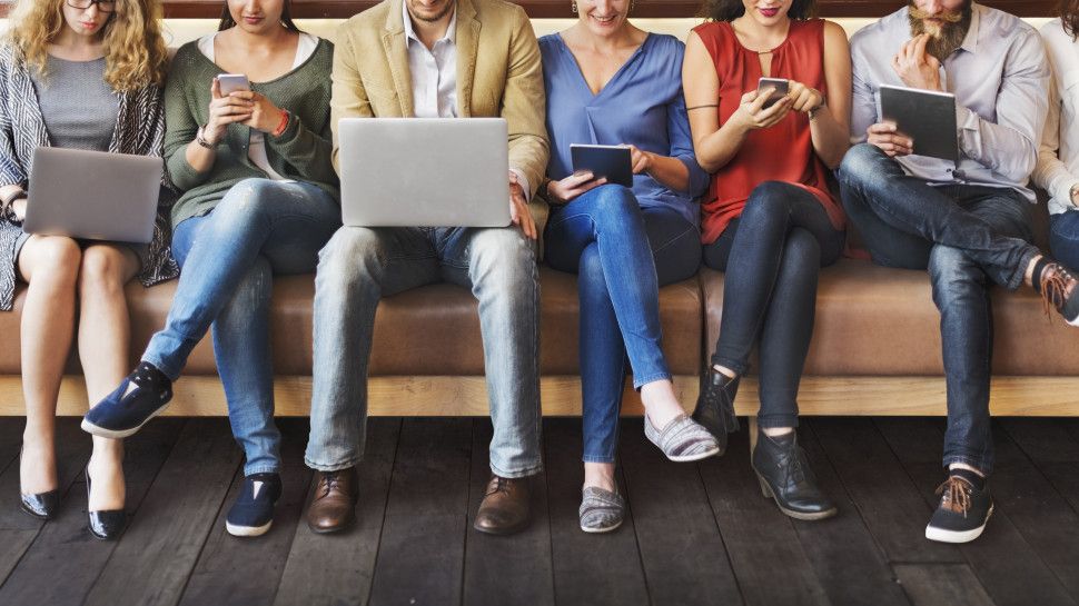 A group of people using laptops, tablets and mobiles