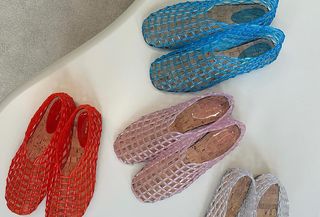 Photo of the Row jelly ballet flats on white table in red, pink, white, and blue.