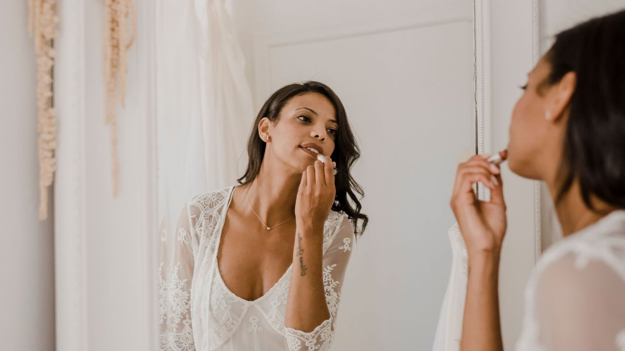 Best lipstick for a wedding - woman applying lipstick on her wedding day