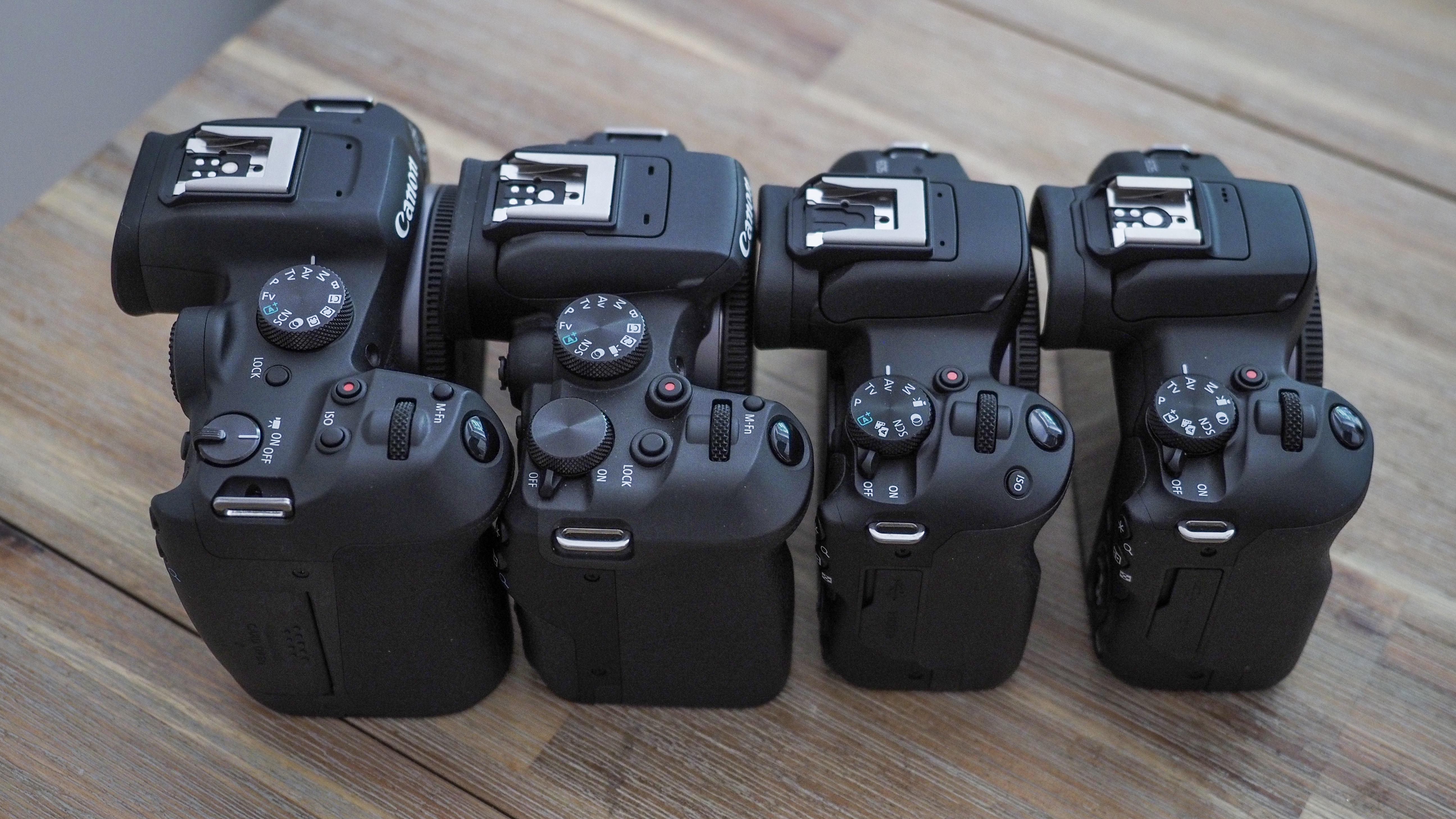 Canon APS-C cameras on a wooden surface