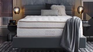 A Saatva Classic mattress on a grey bedframe in a modern bedroom