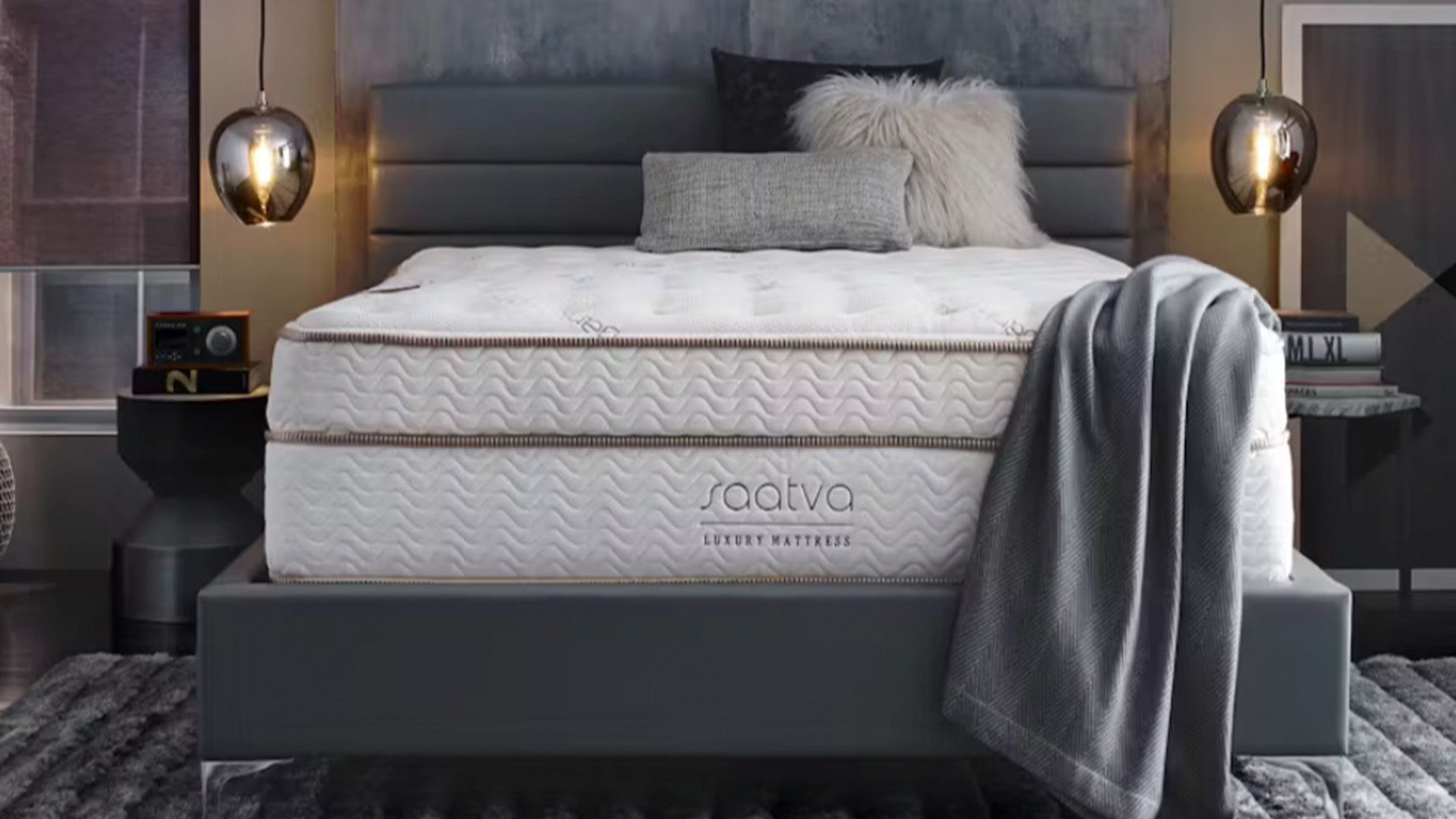 A Saatva Classic mattress on a grey bedframe in a modern bedroom