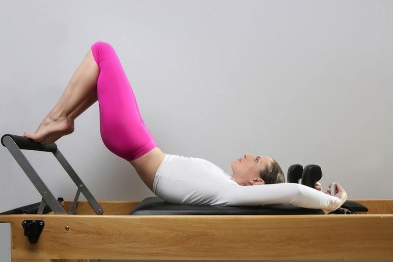 woman going through a pilates reformer class