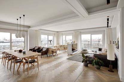 A white room with curtains to the ceiling and low profile furniture