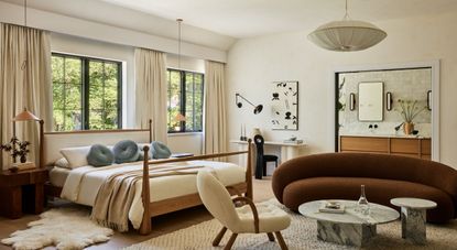 Interior shots depicting an apartment decorated with sculptural furnishings in earthy tones, framed artworks, marble and wood countertops, all bathing in natural light.