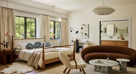 Interior shots depicting an apartment decorated with sculptural furnishings in earthy tones, framed artworks, marble and wood countertops, all bathing in natural light.