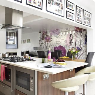 kitchen room with floral printed white walls and kitchen chimney