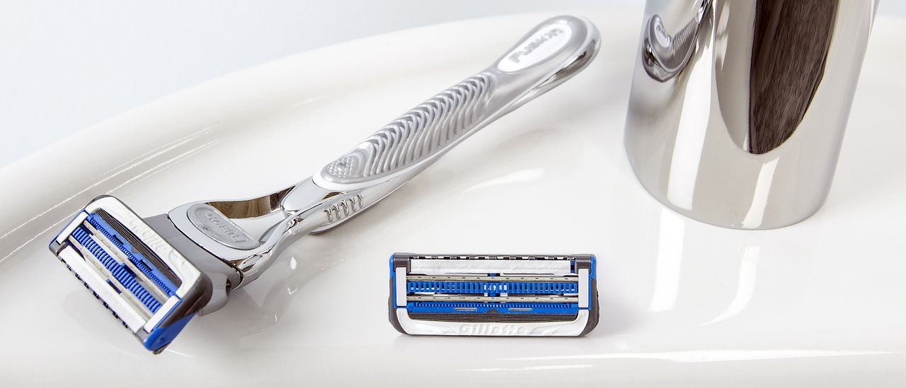 One of the best razors, a Gillette, sitting on a bathroom sink next to a tap