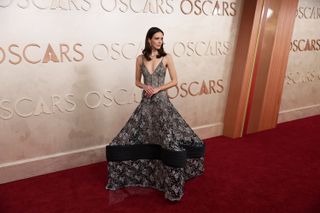 A photo of Stacy Martin wearing a sheer black tented Louis Vuitton gown with silver floral embroidery at the 2025 Oscars.