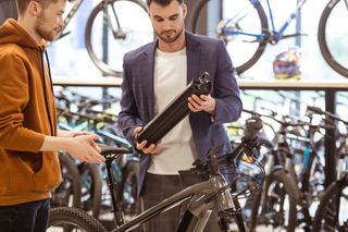 Bike shop worker with e-bike customer