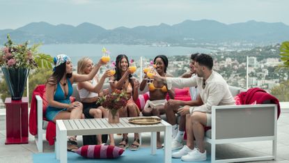 dated and related cast doing cheers outside on the french villa