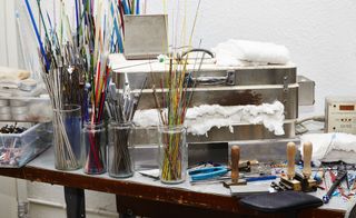 Paint brushes in glass jars in studio