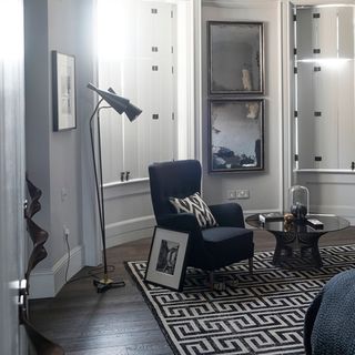 bedroom with coffee table floor lamp black and white photo frame and grecian key rug