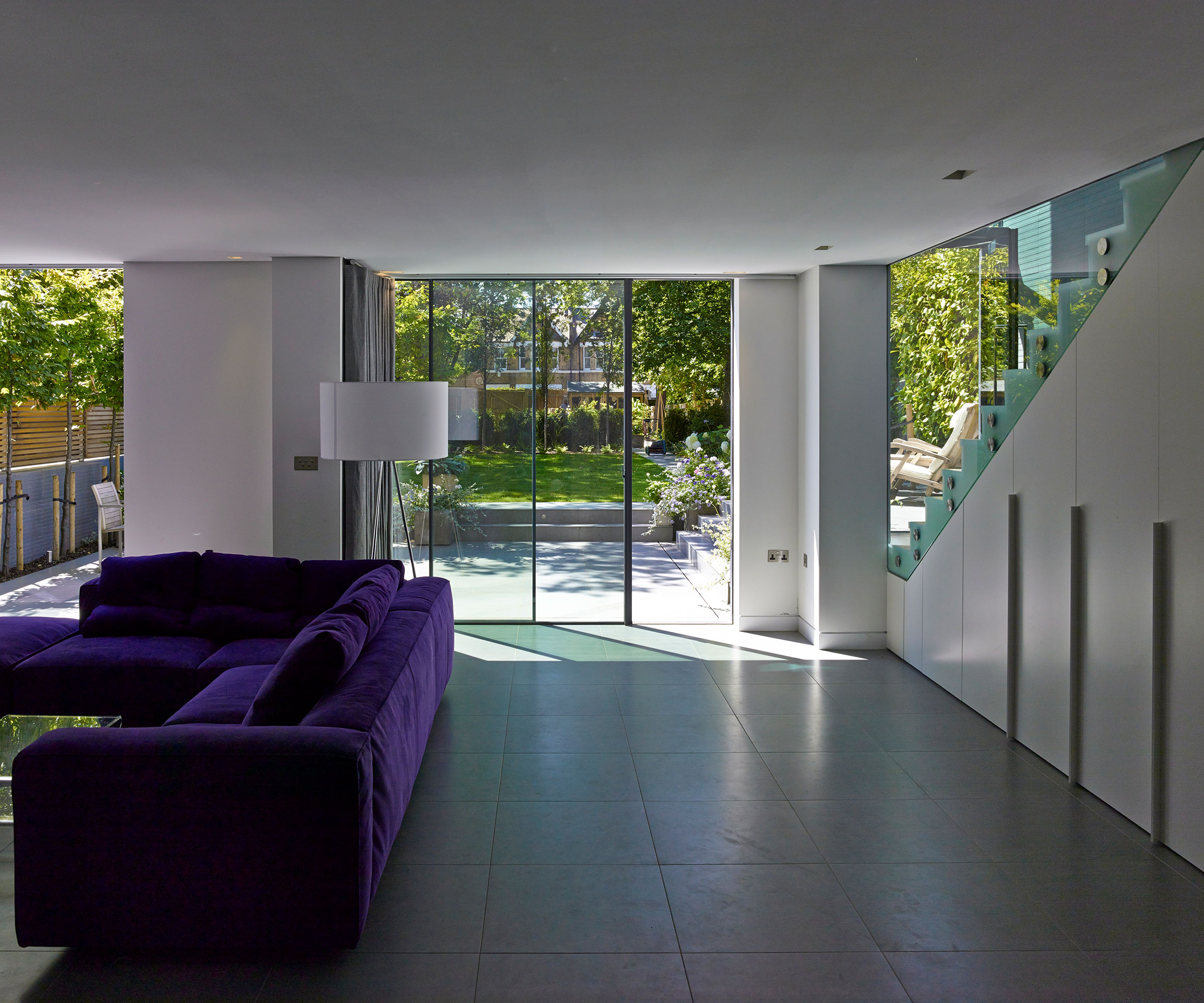 basement conversion living room with sliding doors to outside and purple sofa