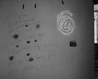 A silver spiral and words scratched into a wall
