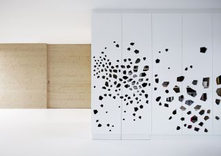 minimalist house in amsterdam with white kitchen cupboards and laser cuts holes in their doors