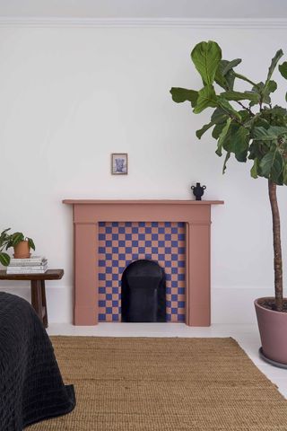 white room with terracotta fireplace with blue checkerboard pattern